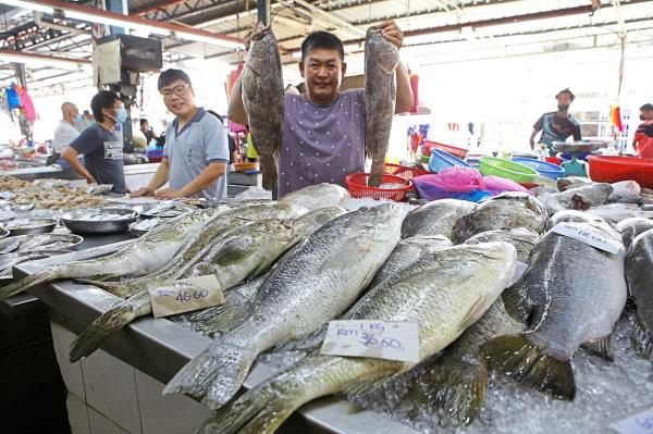 If you need an Insta-worthy moment, you might find friendly fishmo<em></em>ngers more than ready to show off their catch of the day at Cecil Street Market. — CHAN BOON KAI/The Star