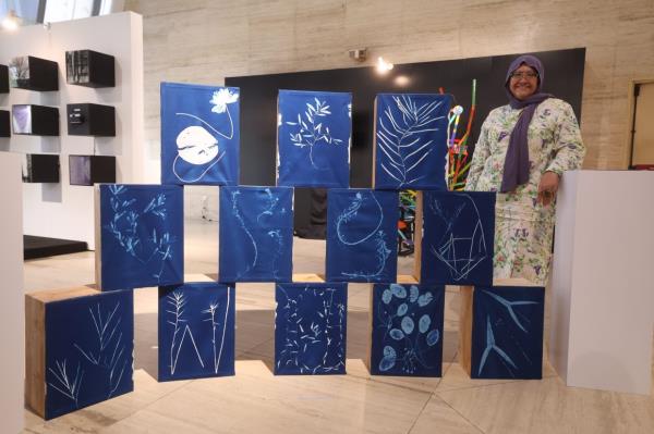 Prof Madya Dr Faridah Qamaruz Zaman posing with her artwork 'Aquascape', which warns of the masses a<em></em>bout the dangers of invasive plant species. Photo: Bernama