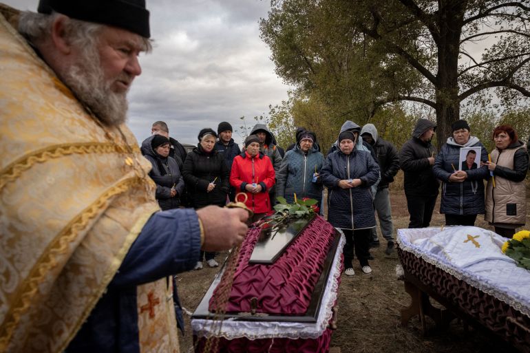 Family and relatives attend the funeral of Iryna Kharbaka and Oleksandr Khodak who were killed in a Russian missile attack, amid Russia's o<em></em>ngoing invasion of Ukraine, at the village cemetery, in the village of Hroza, near Kharkiv, Ukraine October 9, 2023. REUTERS/Thomas Peter
